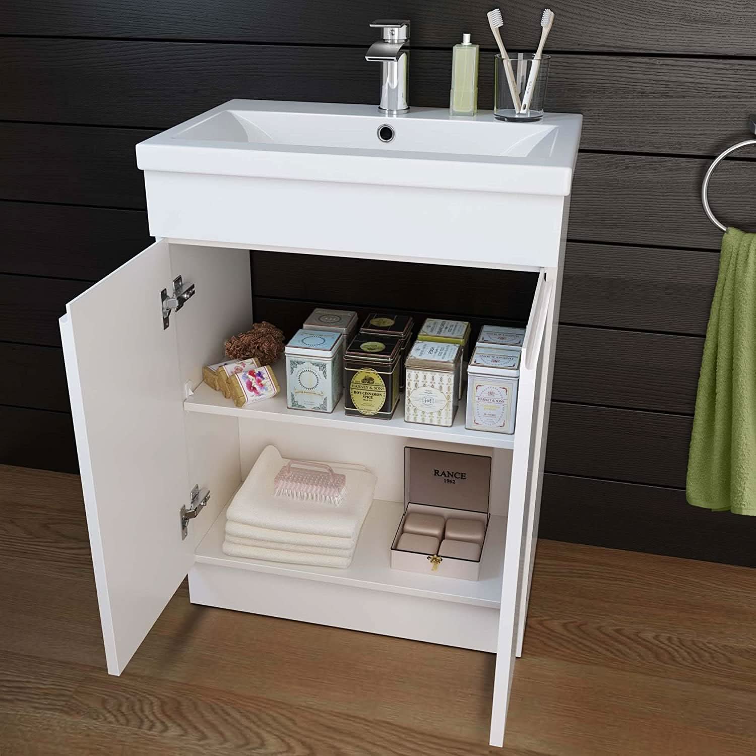 The iBathUK Trent Close Coupled Toilet & Vanity Unit with Basin, a gloss white space-saving combo, stands with its doors open to reveal shelves stocked with soap, towels, and containers. Toiletries and toothbrushes sit neatly atop the basin for a tidy look.