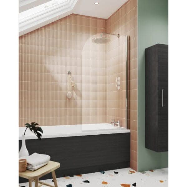 Modern bathroom with a peach-tiled wall, Nuie 1800mm Straight Shower Bath Front Panel With Plinth on the tub, glass shower screen, overhead shower, green accent wall, freestanding towel rack, and terrazzo floor.