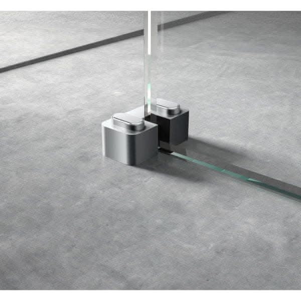 A close-up of the Nuie 44mm Wetroom Screen Support Foot, securely fixed to a smooth gray floor; the support foot complements Nuie wetroom accessories and adds a sleek, modern touch to your frameless glass shower setup.