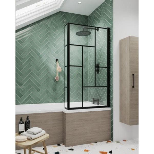 Modern bathroom featuring green herringbone tiles, a wood-paneled bathtub, the Nuie Abstract Framed Shower Bath Screen in matt black, wall-mounted showerhead, wooden cabinet, white ceiling, and a multicolored tile floor.