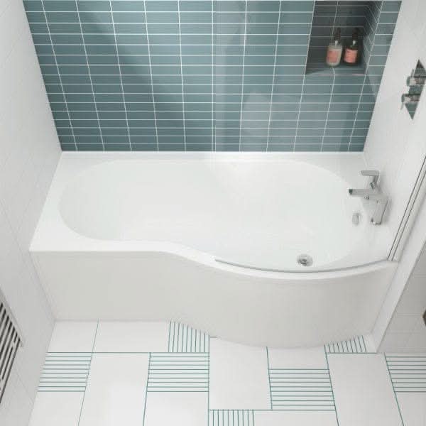 The Nuie Square P Shape Shower Bath in white by Nuie features a modern curved design, set against blue-green tiles with a built-in shelf. White floor tiles with thin blue lines complete the look, ideal for a contemporary bathroom.