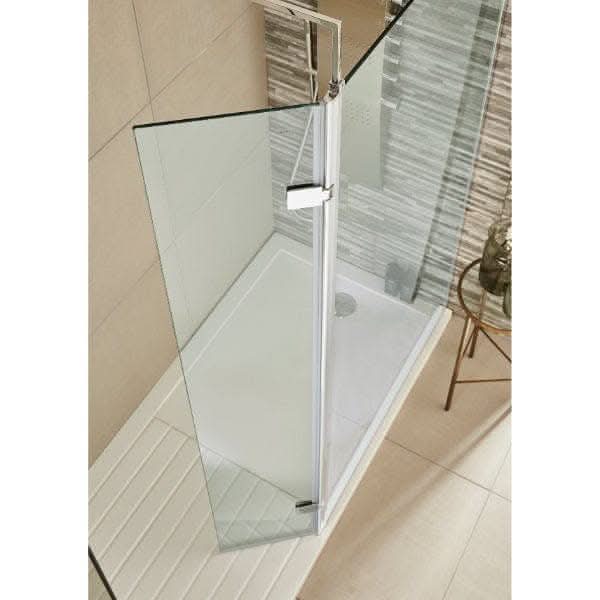 A Nuie Wetroom Return Screen by Nuie is featured in a modern, frameless glass shower with a white tray, beige wall tiles, and a striped accent. A small round table is also visible, creating a contemporary bathroom look.