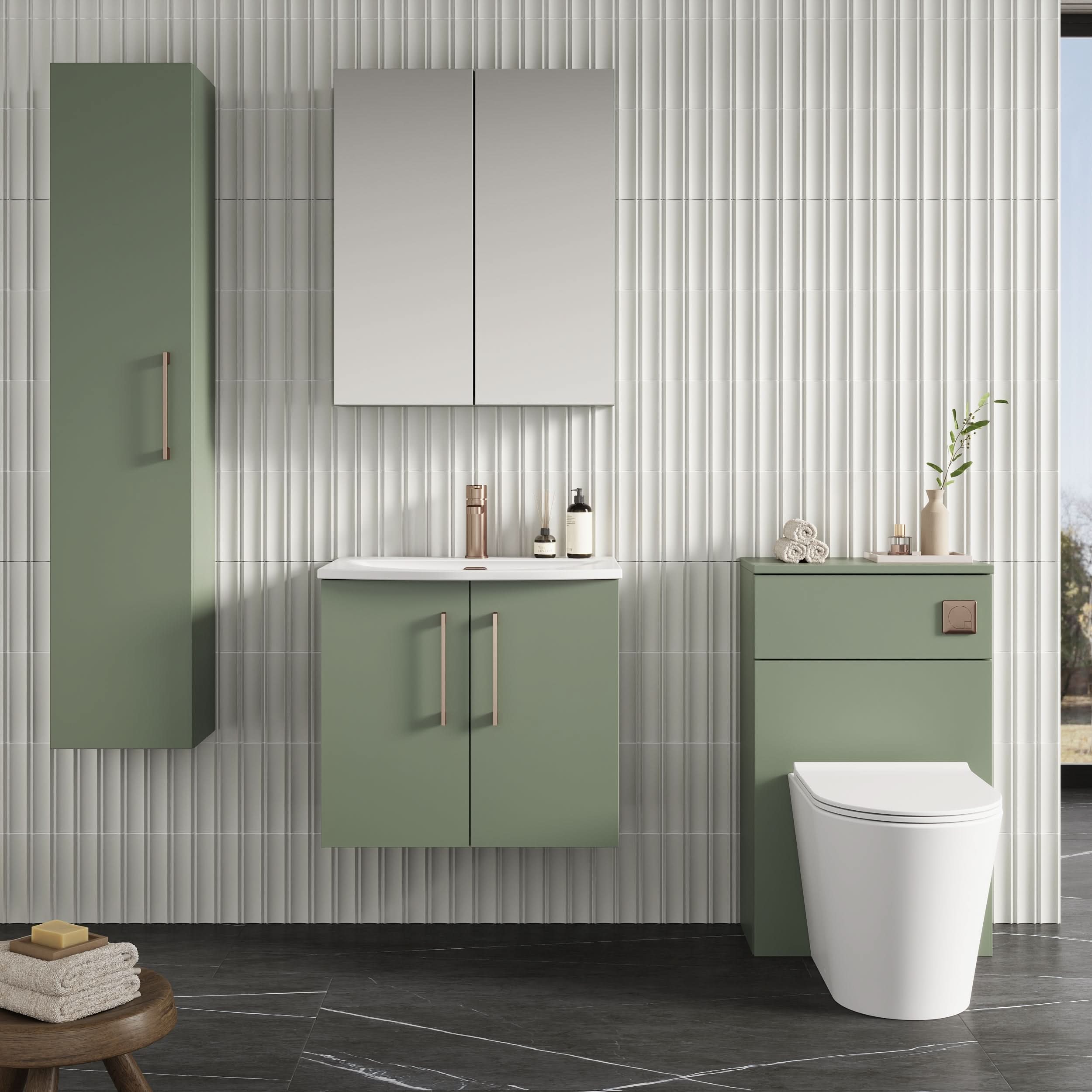 Modern bathroom with sage green cabinets, a Nuie Arno 2 Door Wall Hung Vanity Unit With Basin-4 600mm Wide, double mirrors, toilet, minimal accessories on white textured tile walls and black marble floors. A window brings in natural light.