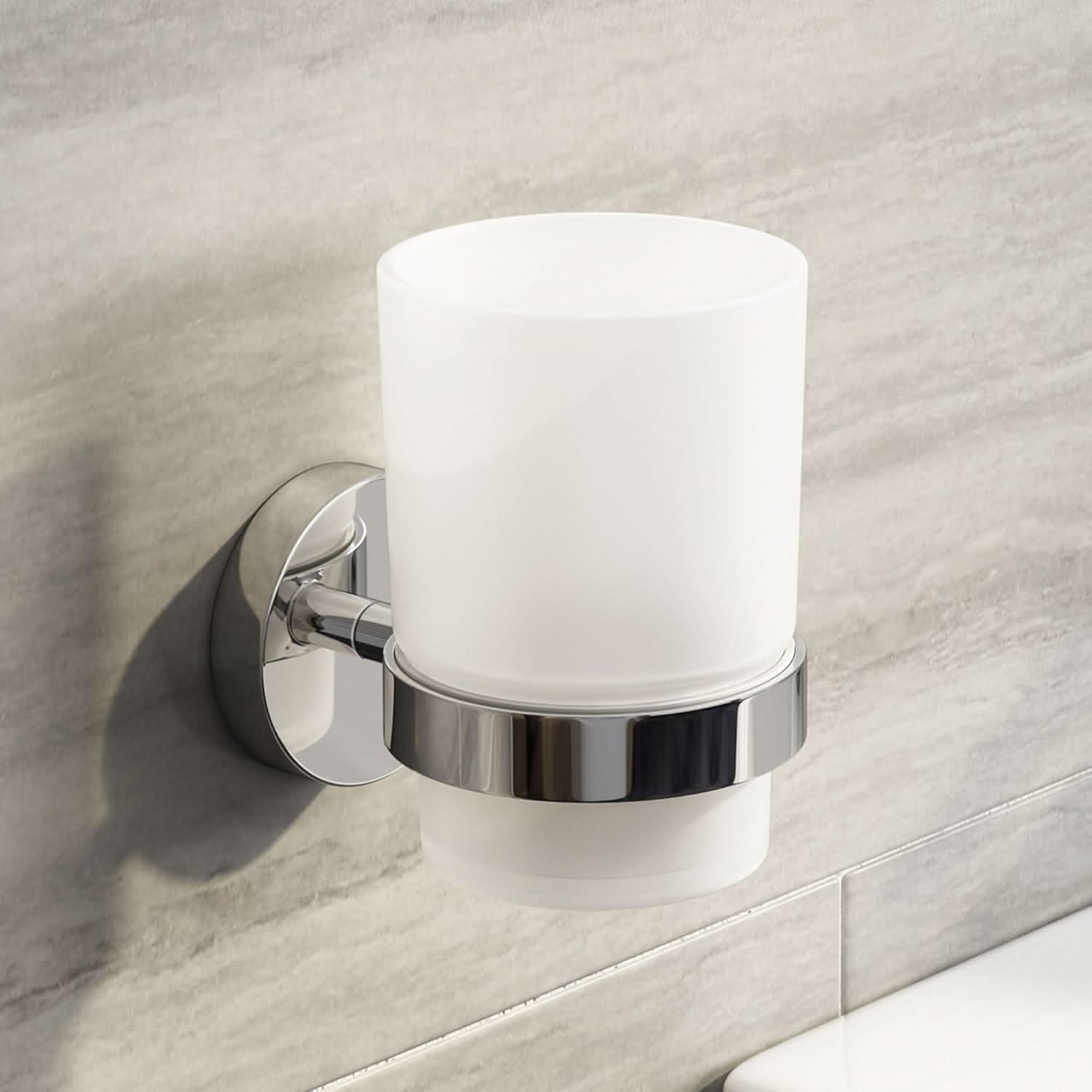 The iBathUK Lumo Designer Bathroom Accessory Set features a wall-mounted chrome toothbrush holder with a frosted glass tumbler, shown attached to a light gray tiled bathroom wall above a white surface.