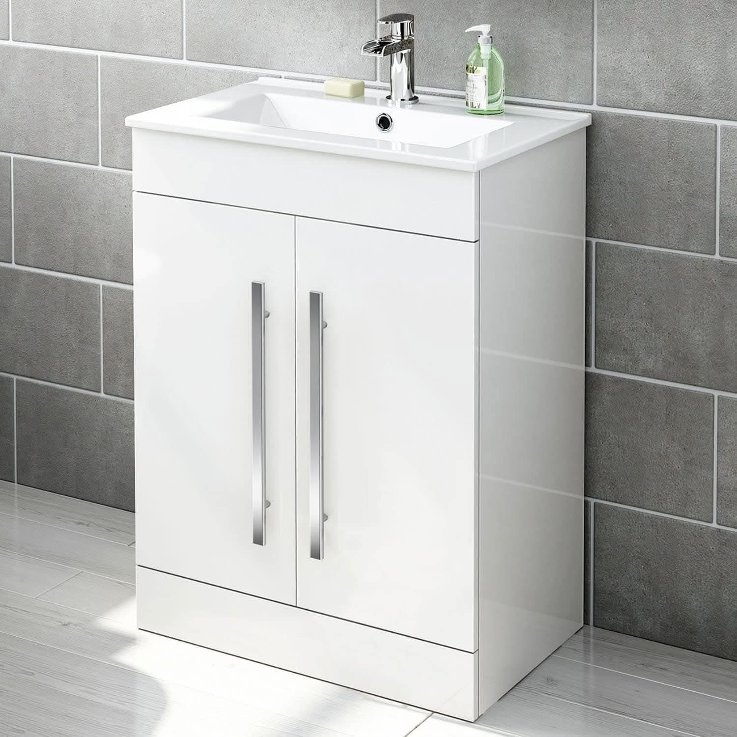 The Avon 2 Door Floorstanding Vanity Unit With Basin (615mm x 815mm, 1 Tap Hole) by iBathUK features two doors with sleek silver handles and a white basin, perfectly complementing gray tiled walls and a light tiled floor.