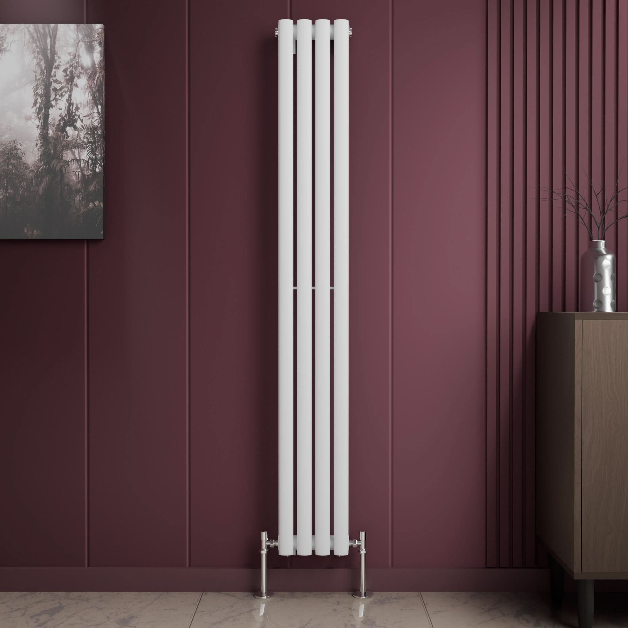 The iBathUK Princia Vertical Single Oval Panel Radiator in white stands against a dark mauve wall with decorative grooves, flanked by a framed picture on the left and a cabinet with a vase and branches on the right, atop light-colored tile flooring.