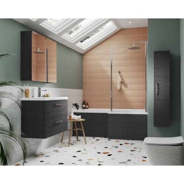 Modern bathroom with green walls, skylights in a sloped ceiling, peach tile accent wall, terrazzo floor, dark wood cabinets, a bathtub fitted with the Nuie 1700mm Shower Bath Front Panel and glass screen, plus a small wooden stool with towels.