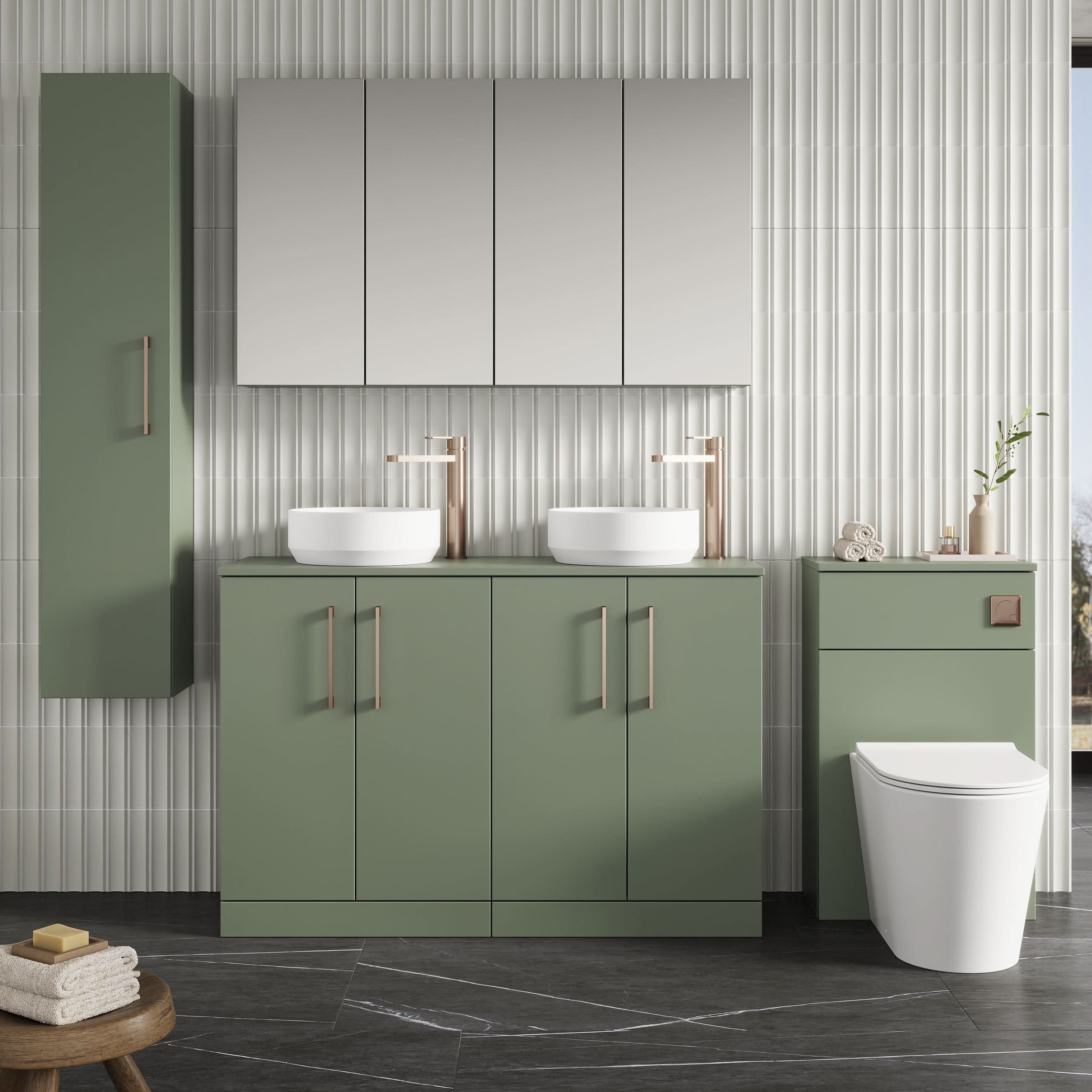 Modern bathroom with sage green Nuie Arno 4 Door Floorstanding Vanity Unit With Worktop (1200mm), double sinks with gold faucets, a wall mirror cabinet, white toilet, striped white wall tiles, and neatly arranged towels and decor on a stool.